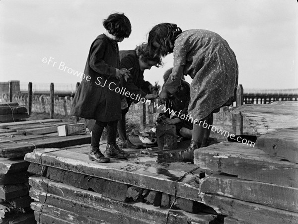 CHILDREN PLAYING ON STACK OF SLEEPERS